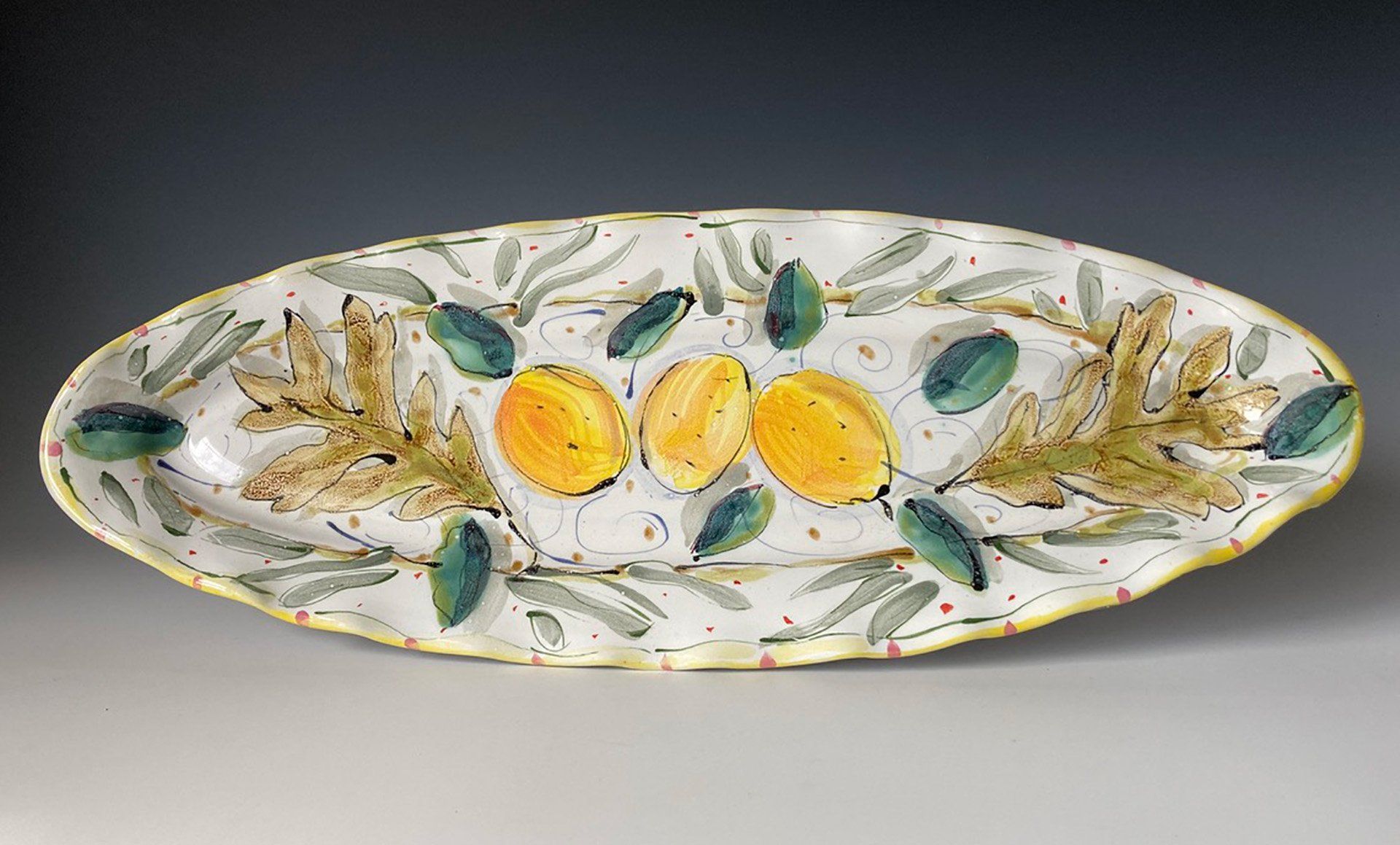 A white plate with yellow lemons and green leaves on it