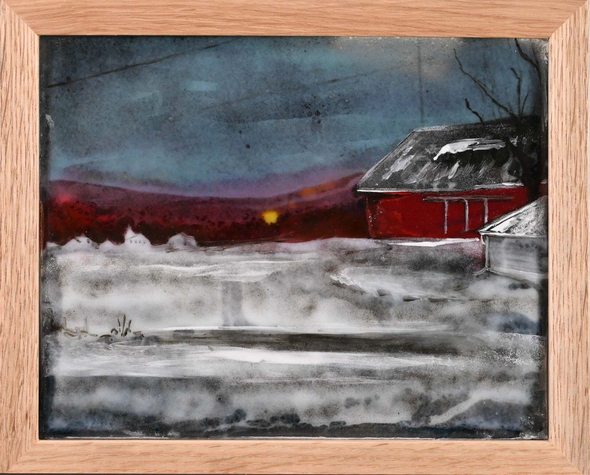 A framed painting of a red barn in the snow