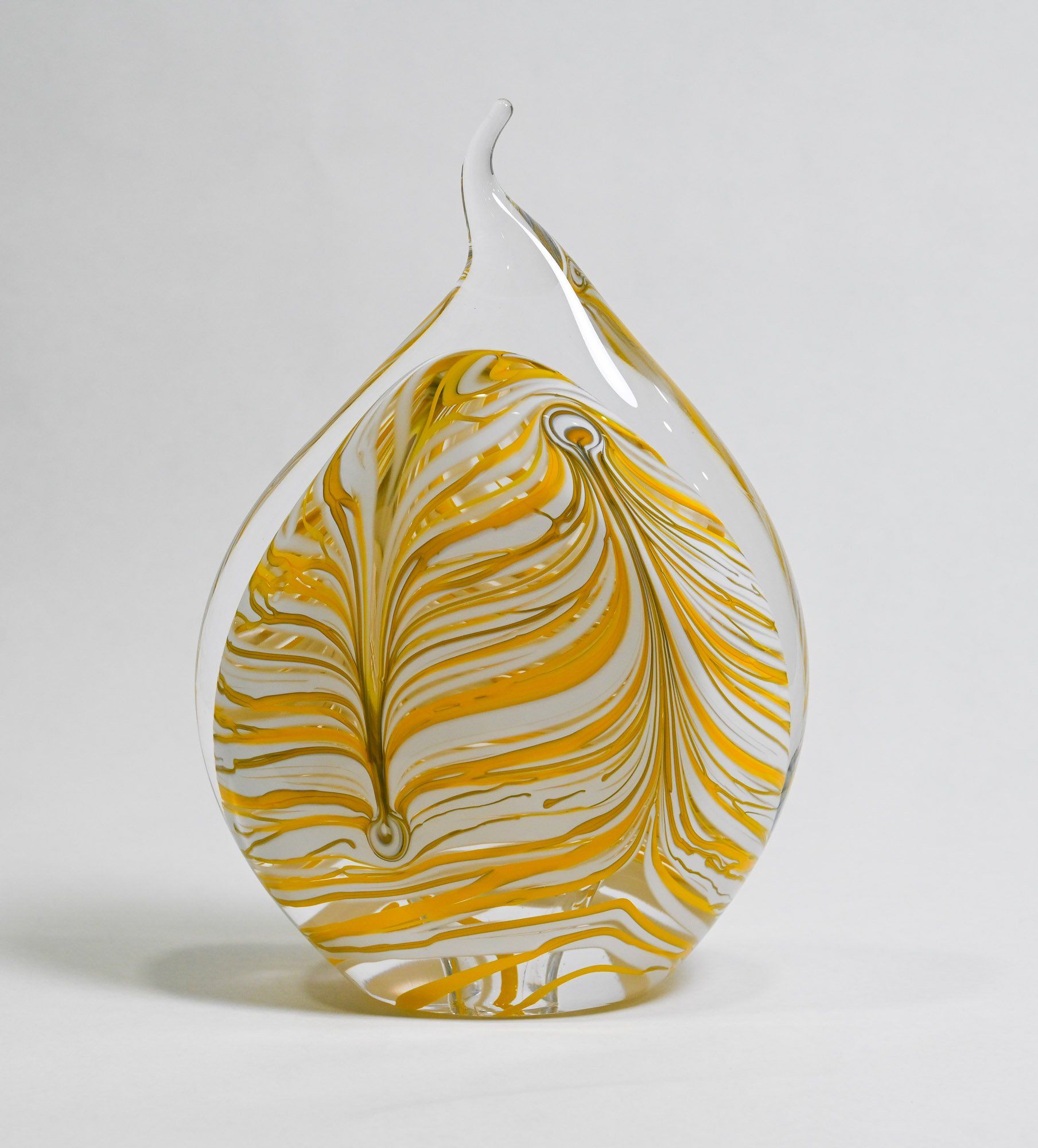 A glass sculpture with yellow and white stripes on it