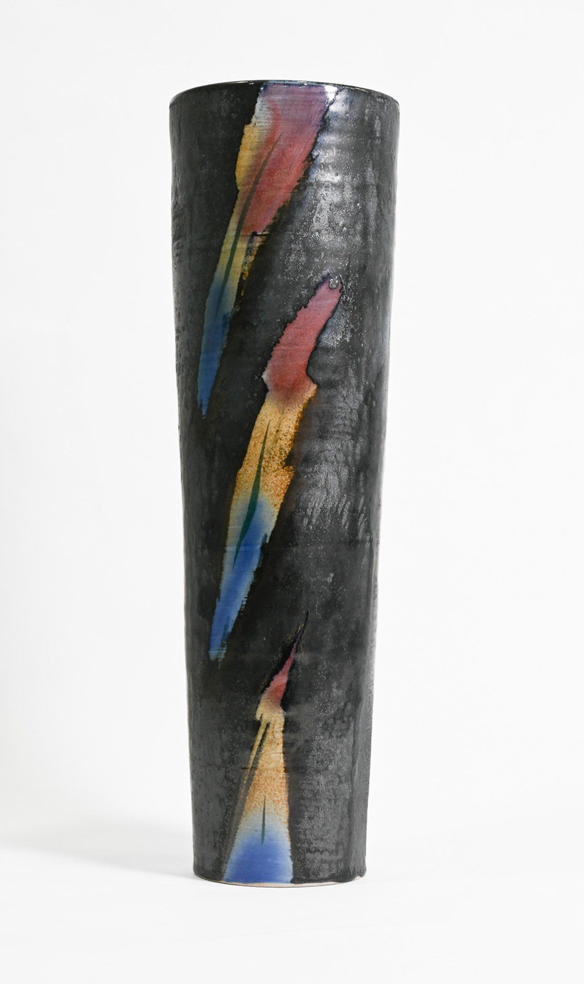 A black vase with a colorful design on it on a white background.