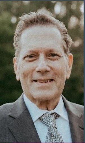 A man in a suit and tie is smiling for the camera.