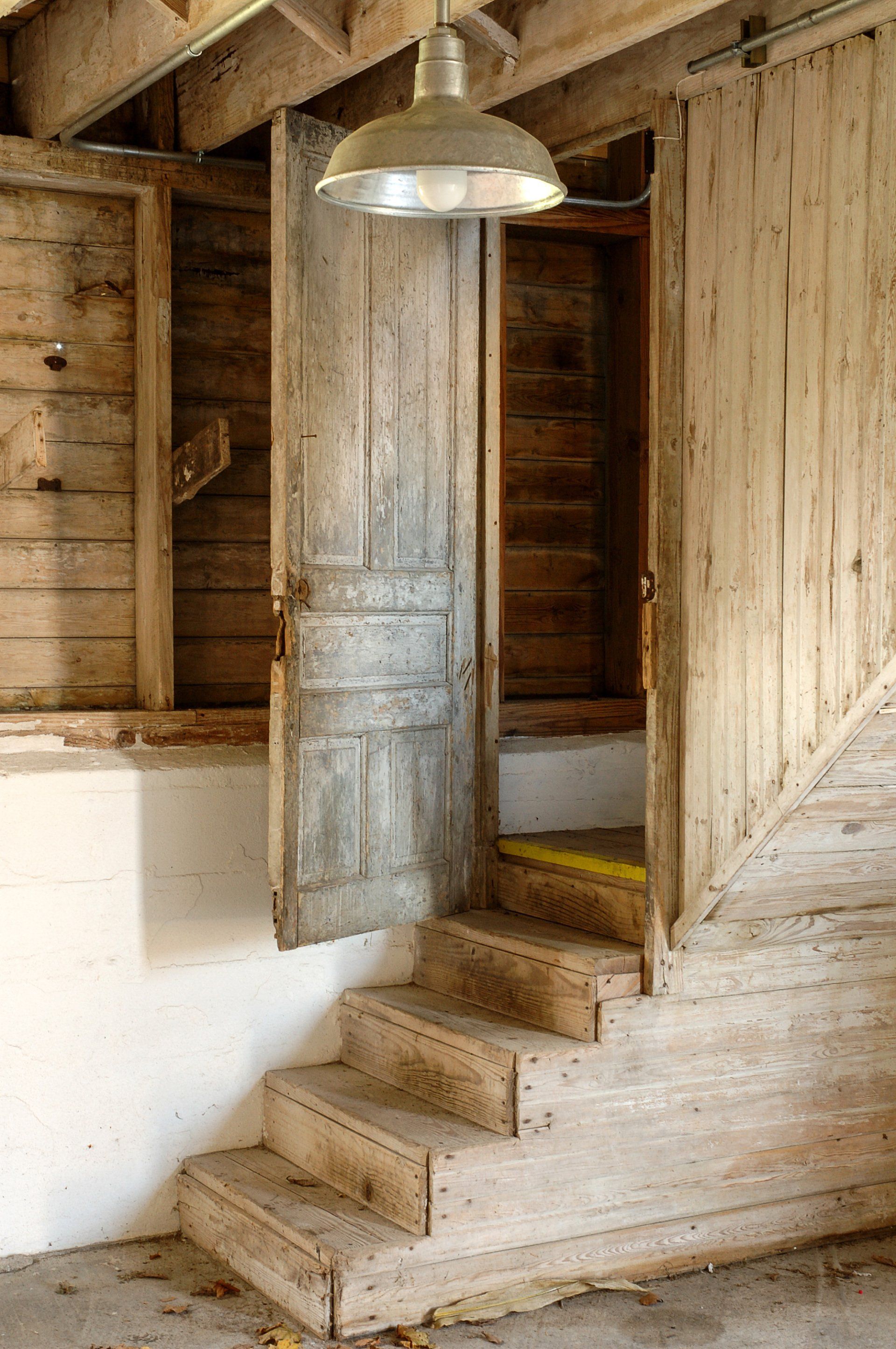A wooden staircase leading up to a door in a wooden building.