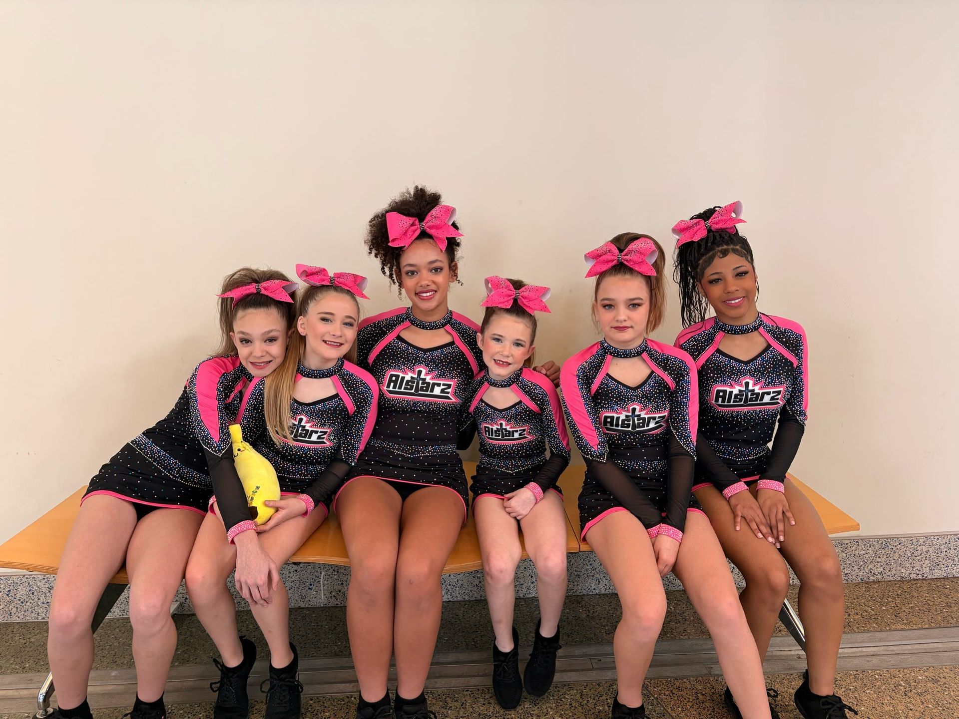 A group of cheerleaders are standing on a field holding pom poms.