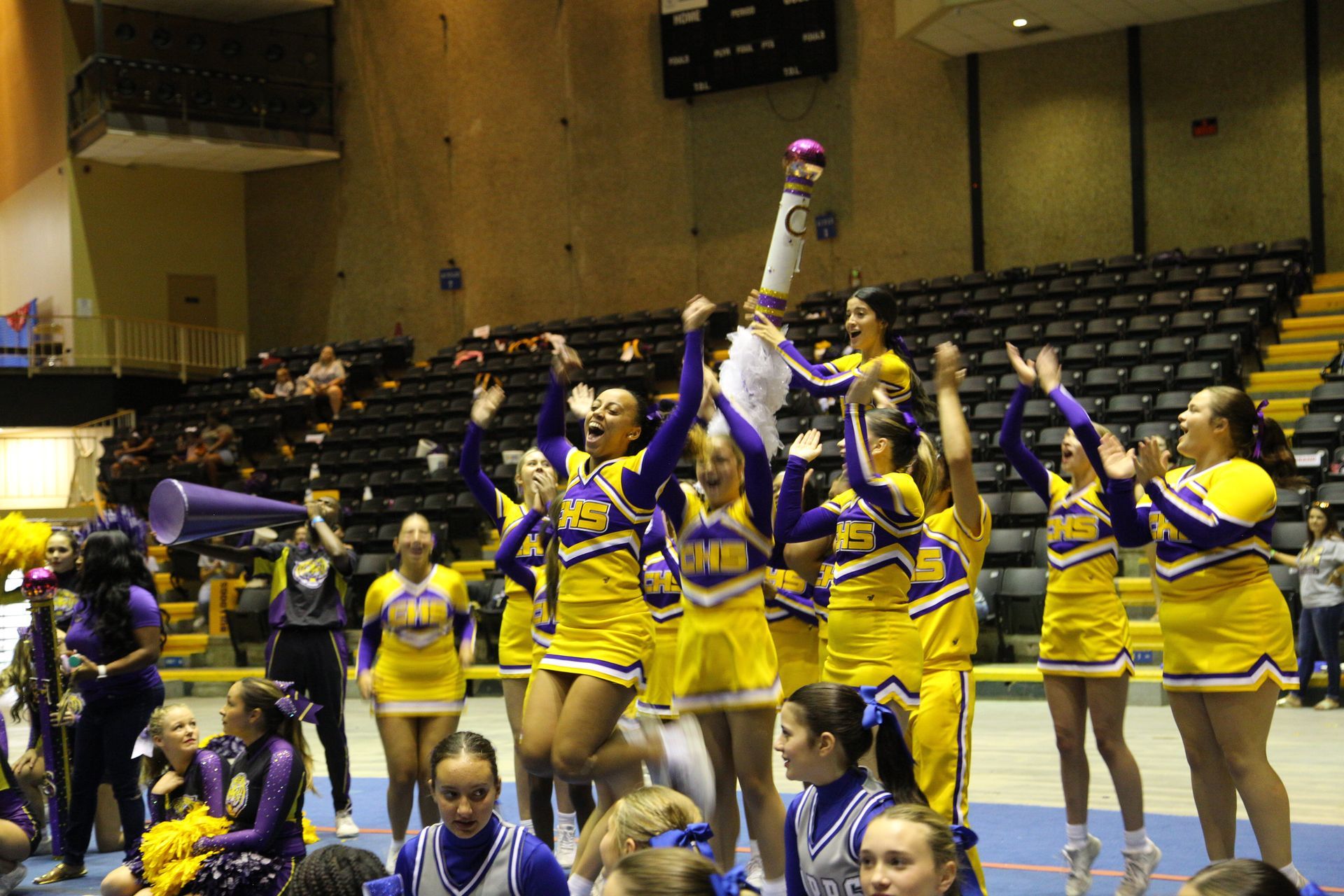 A group of cheerleaders are posing for a picture with the words shining stars behind them.