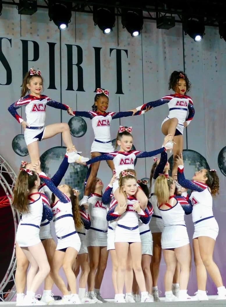 A group of cheerleaders are performing in front of a sign that says spirit