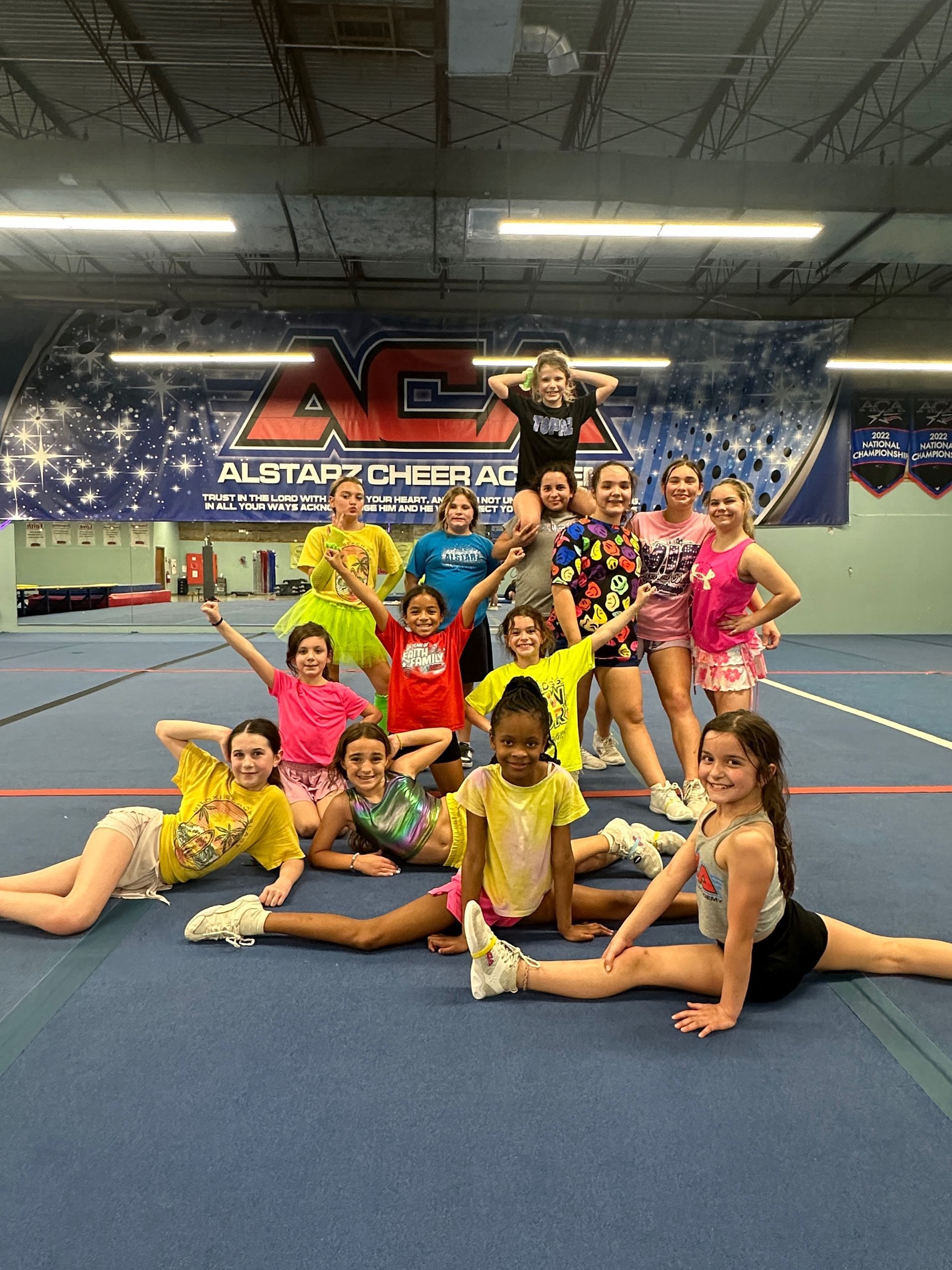 A group of young girls are posing for a picture in a gym.