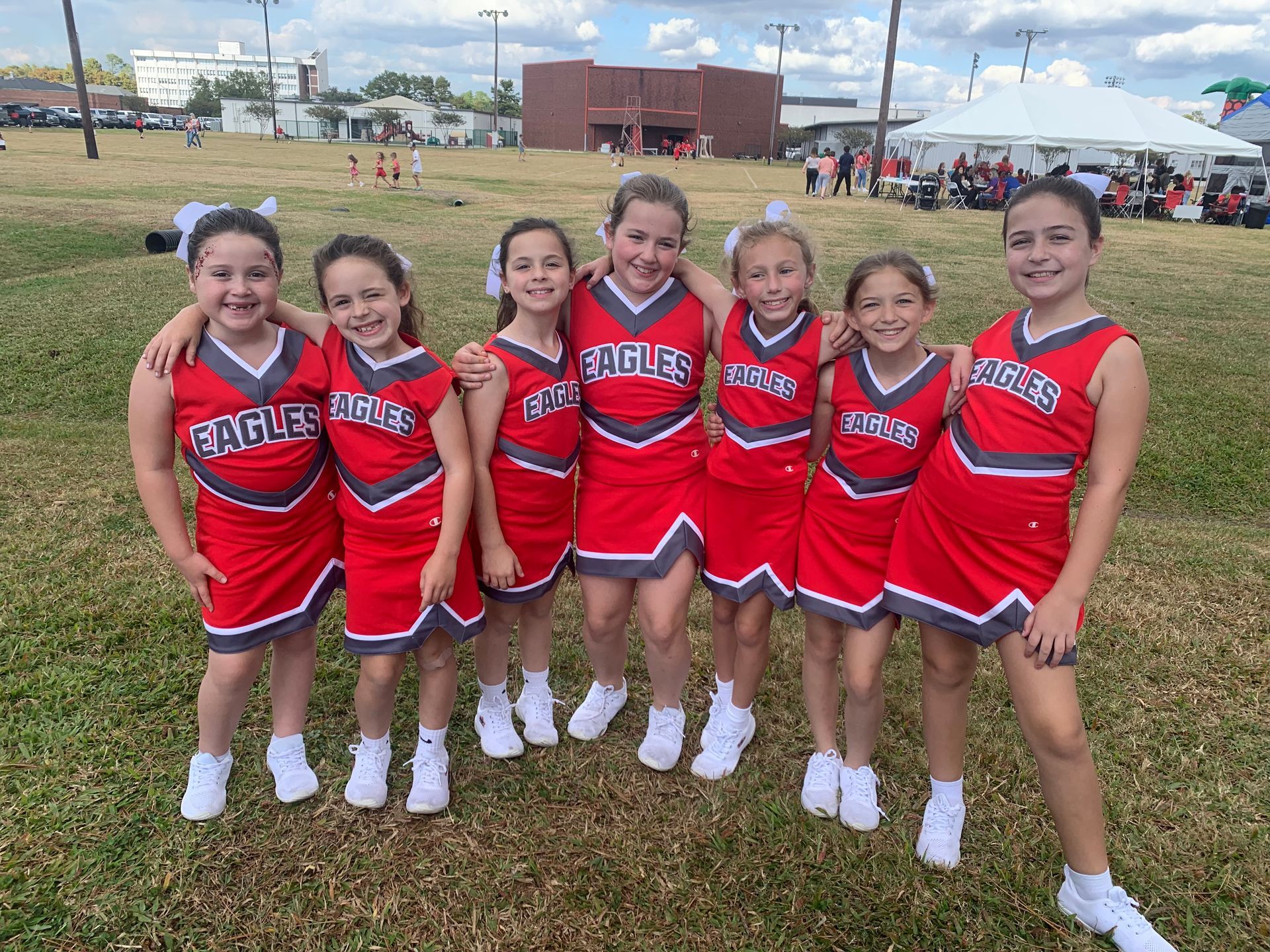 A group of cheerleaders are posing for a picture in a gym.
