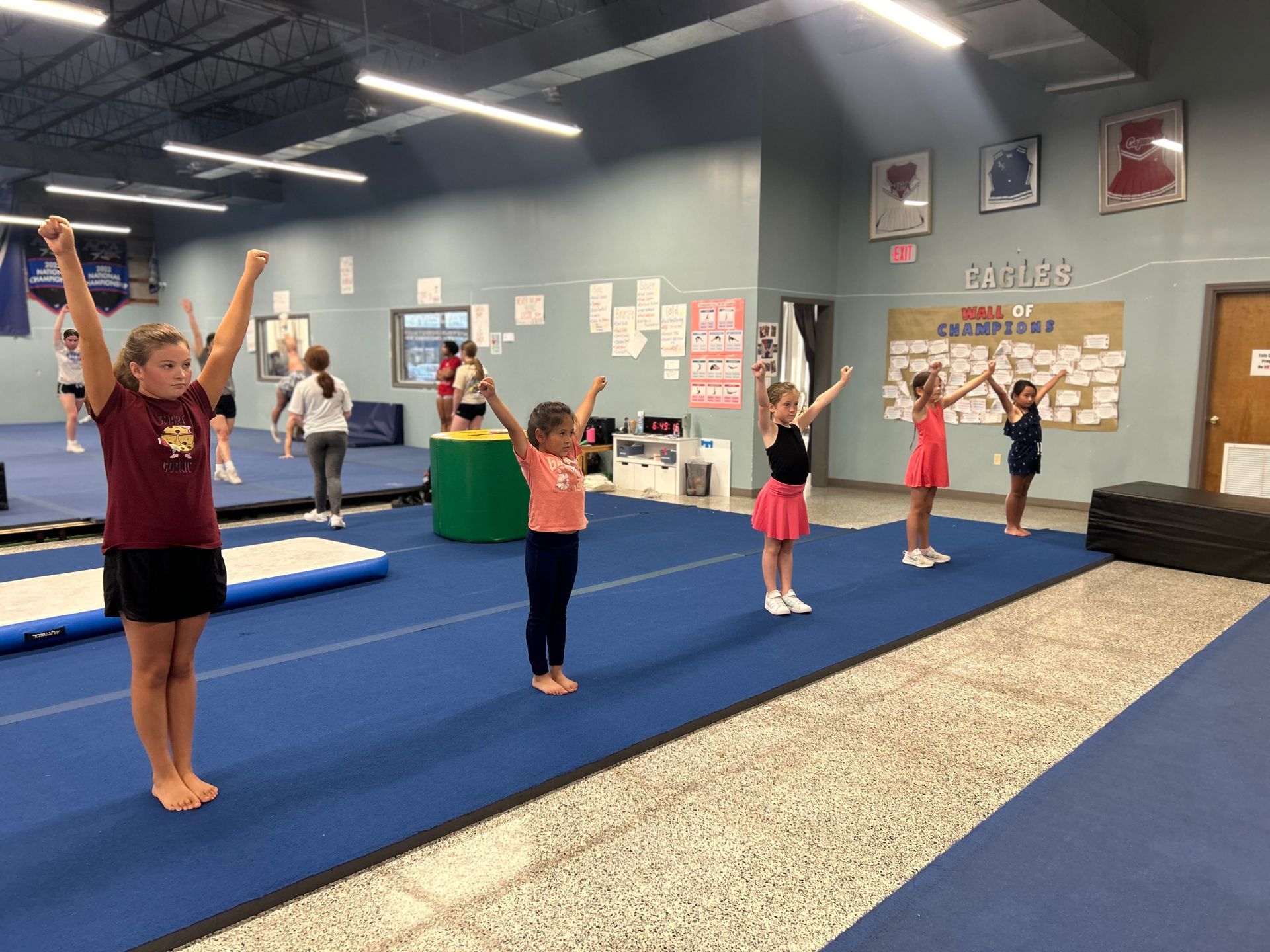 A group of young girls are practicing gymnastics in a gym.