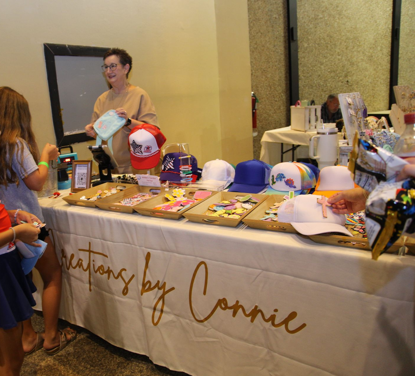 A woman is helping two young girls do exercises on a balance beam in a gym.