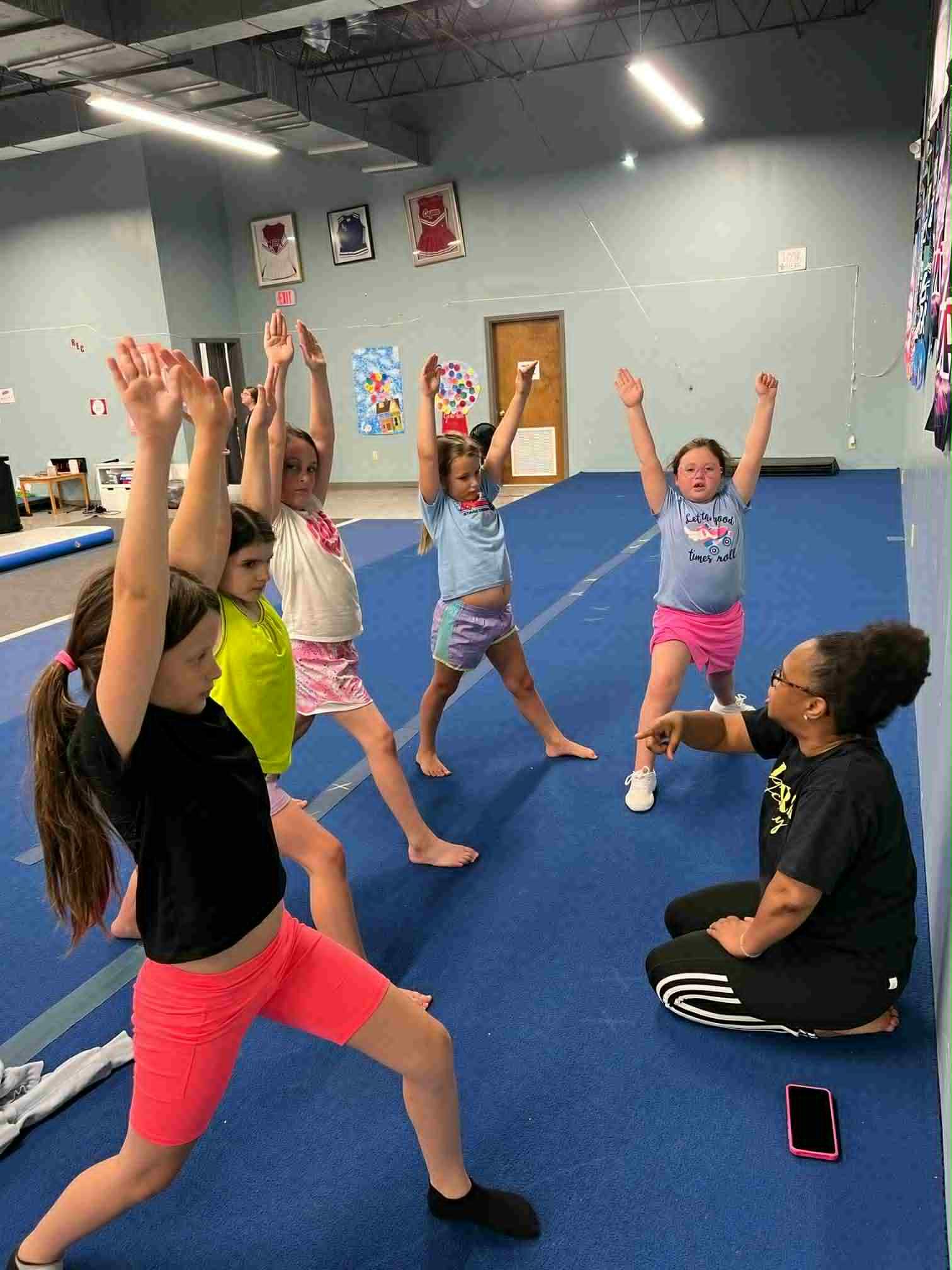 A girl is carrying another girl on her shoulders in a gym.
