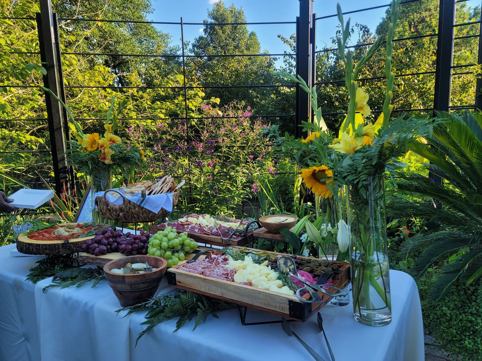 A table with a variety of food and flowers on it.