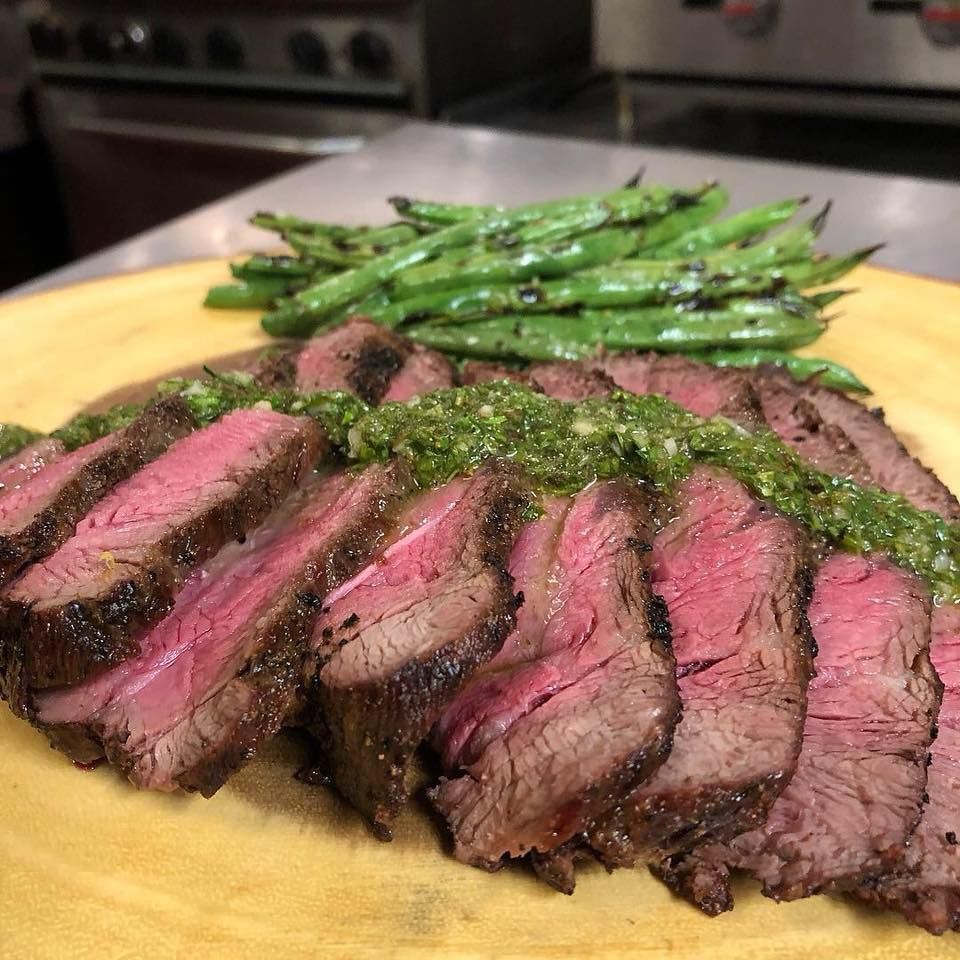 A plate of steak and green beans on a table