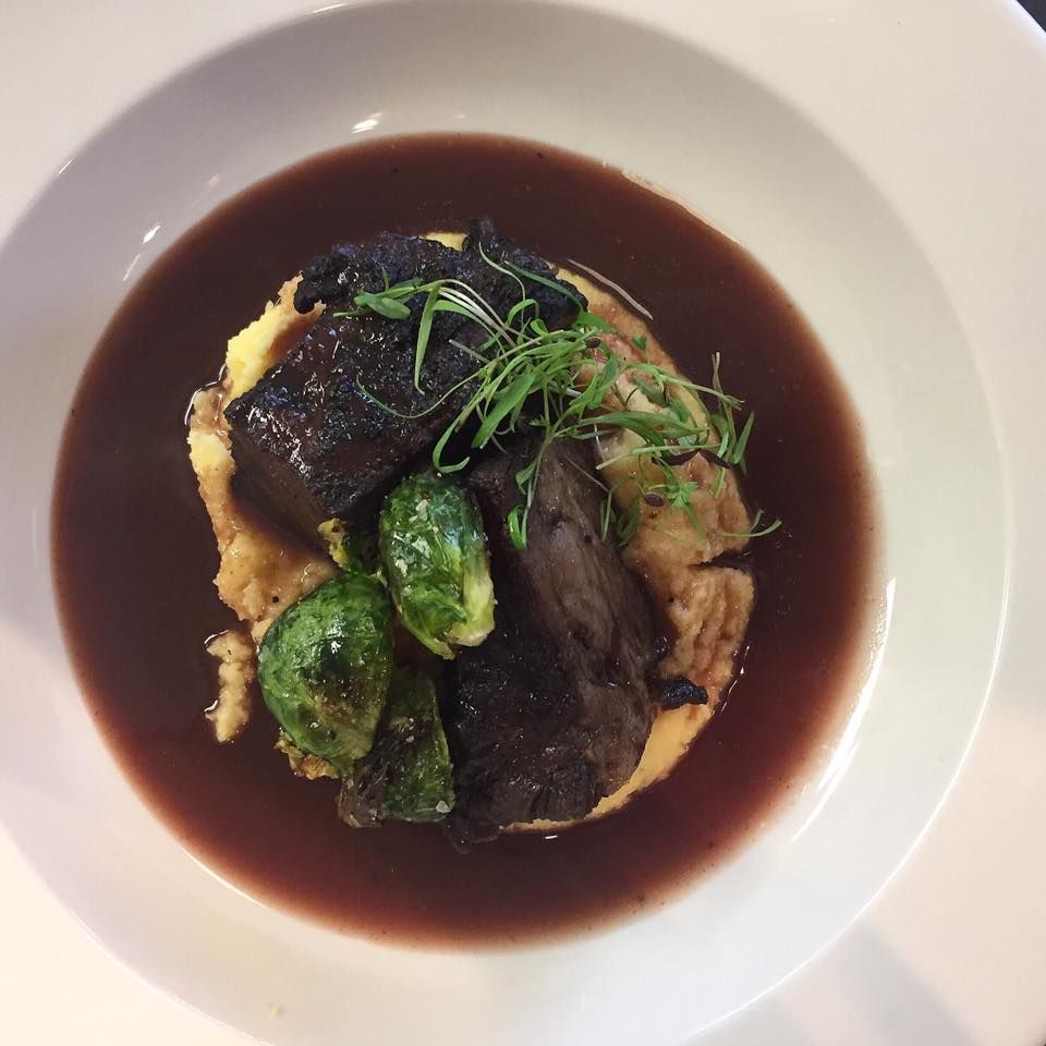 A close up of a plate of food with mashed potatoes and broccoli
