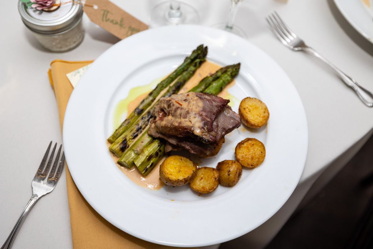 A plate of food with asparagus and potatoes on a table.