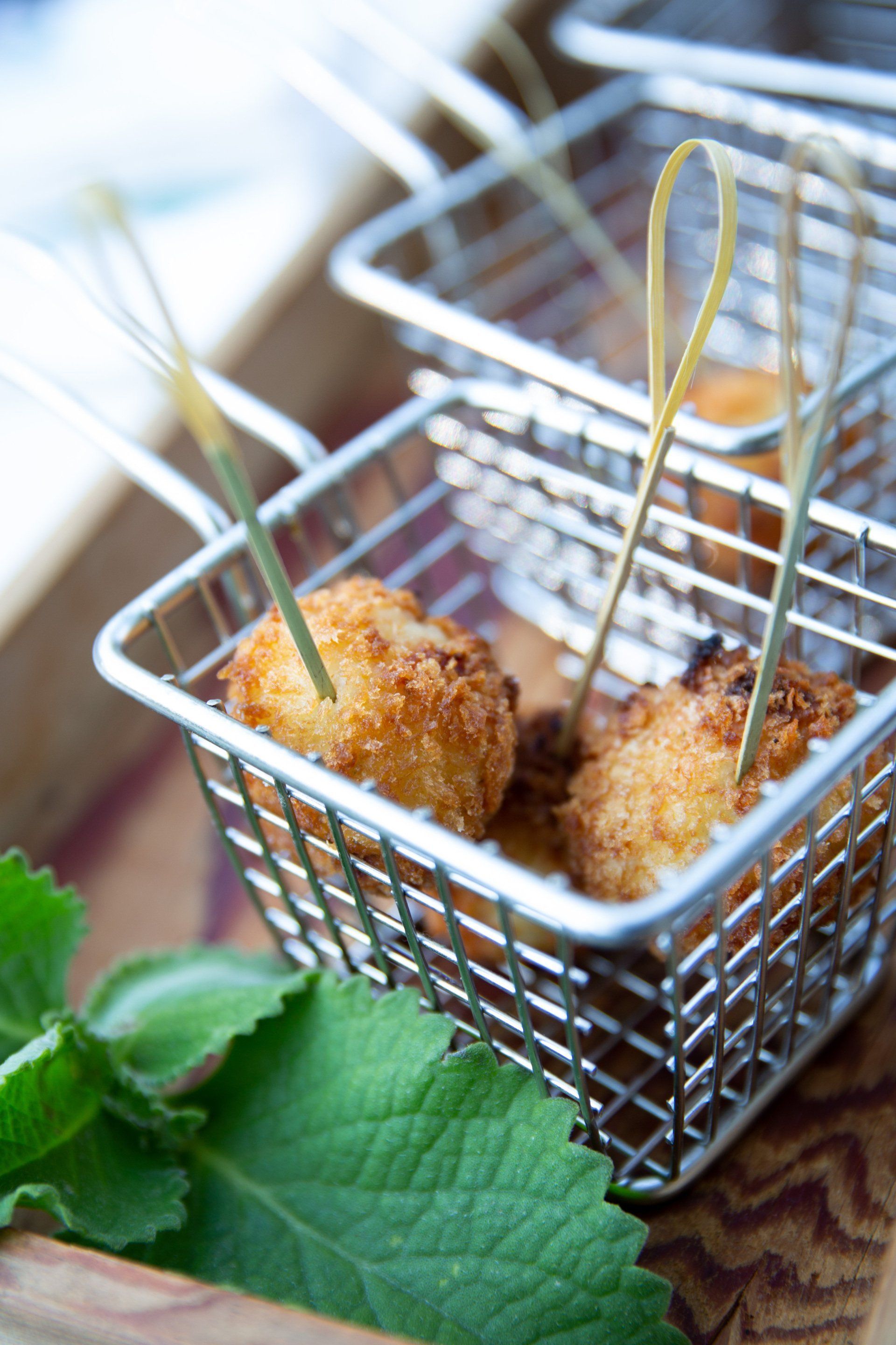 A close up of a basket of food with toothpicks in it