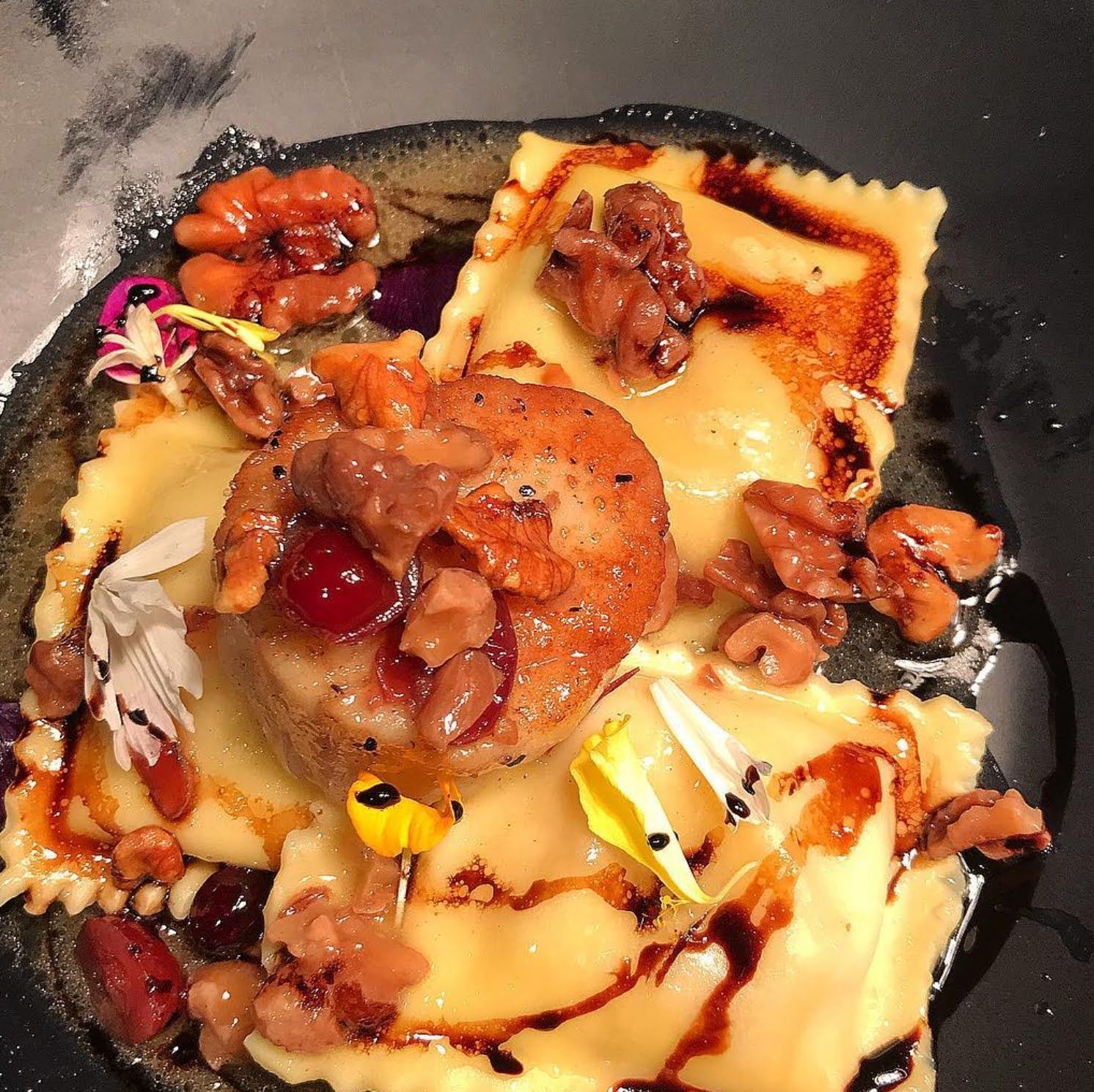 A close up of a plate of food with ravioli and nuts