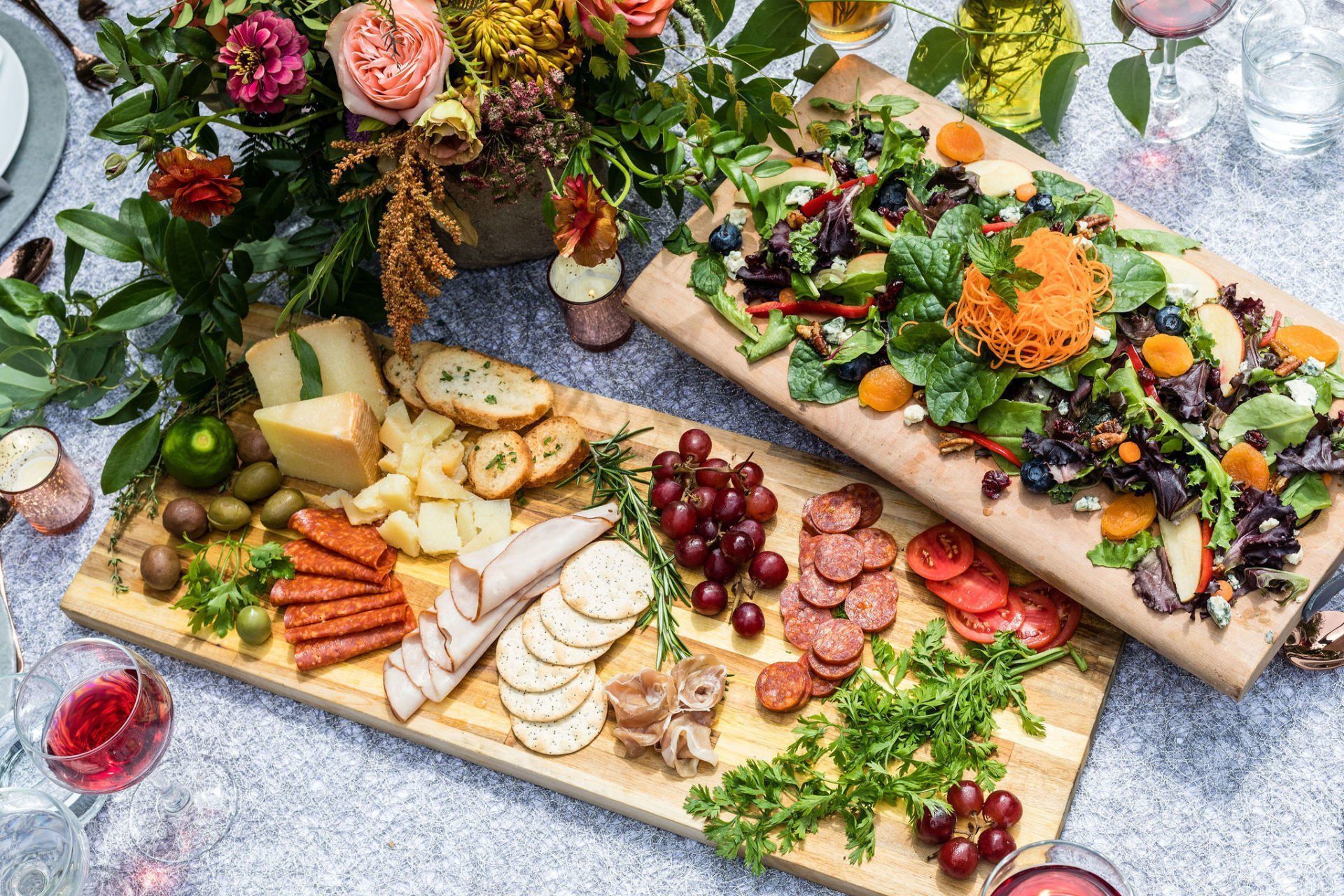 There are two cutting boards filled with different types of food on a table.