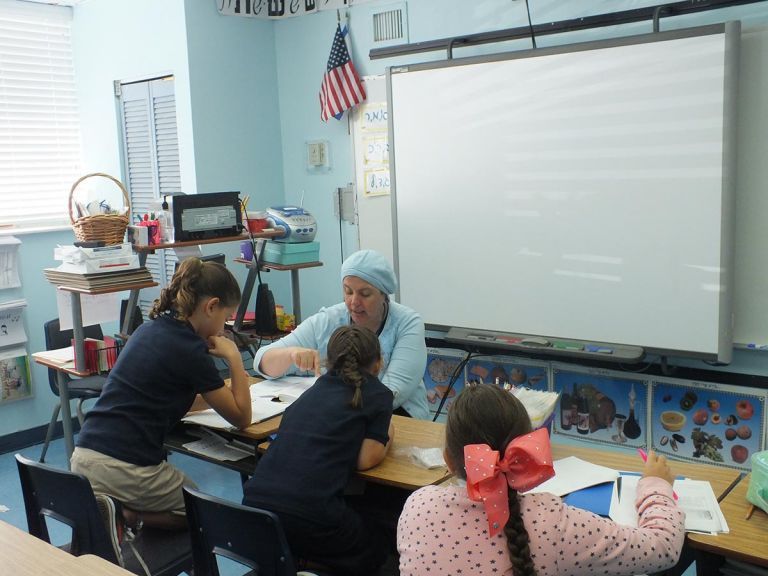 A teacher is teaching a group of children in a classroom