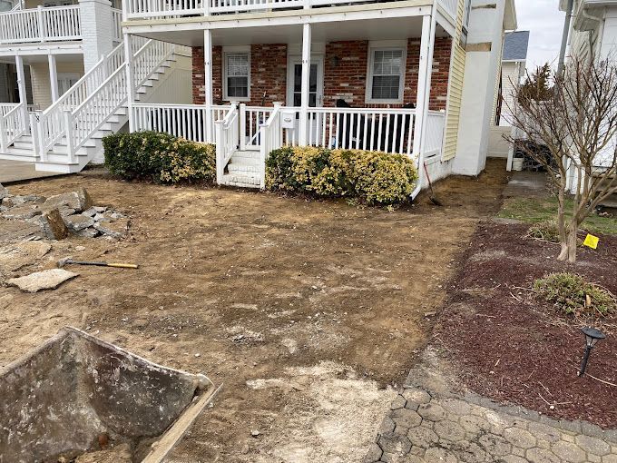 A house with a white porch and stairs is being remodeled by stone works masonry inc.