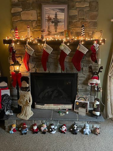 A renovated fireplace decorated for Christmas with stockings and stuffed animals