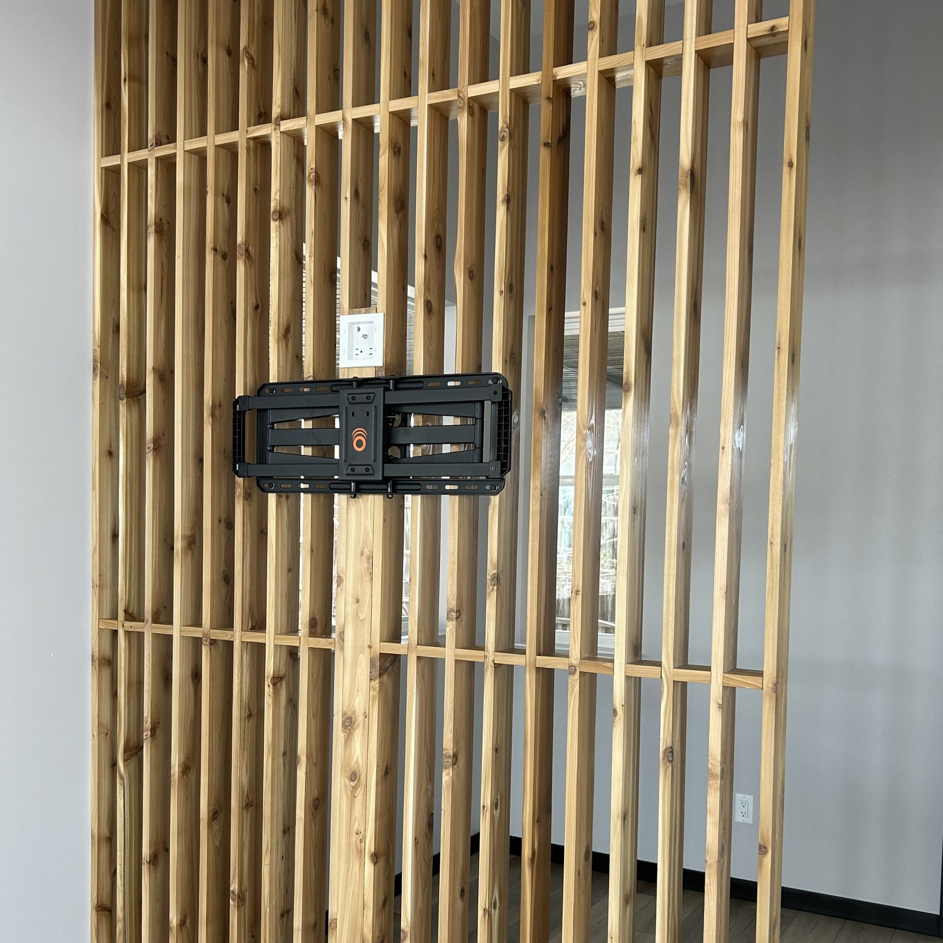 Wooden slat wall with a black object mounted.