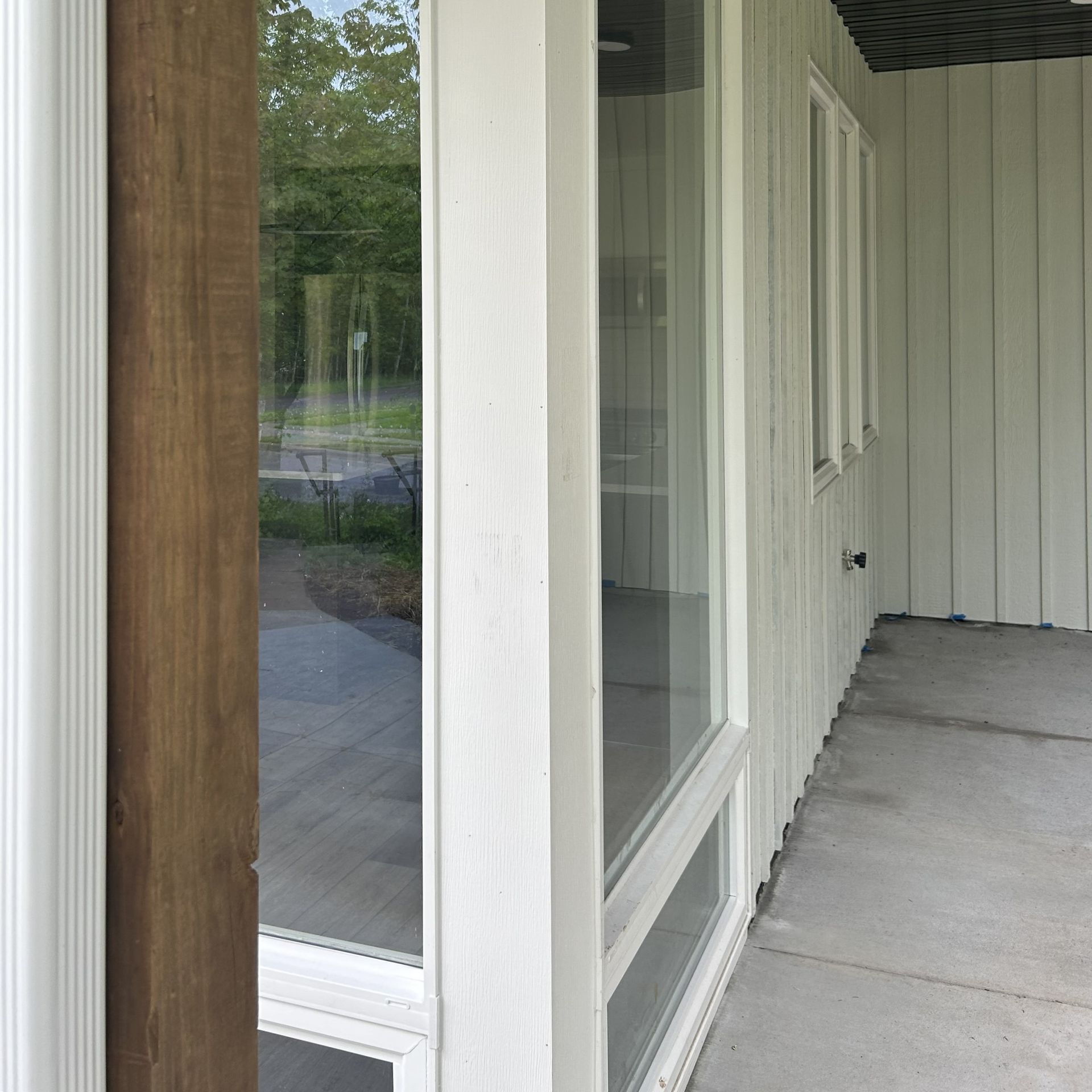 Exterior view of a building with windows and a porch. The siding is light green.