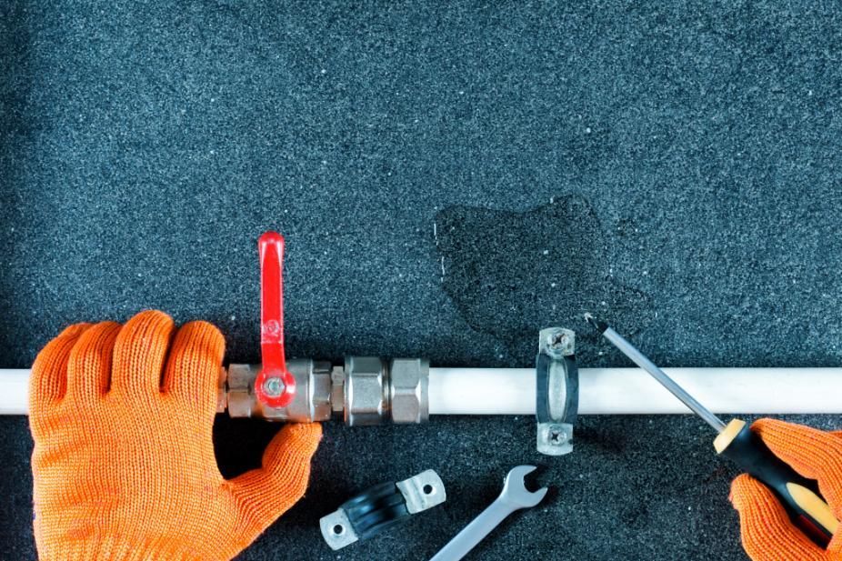Hands in Orange Gloves Repairing a Leaking Pipe — ABV Plumbing In Umina Beach, NSW