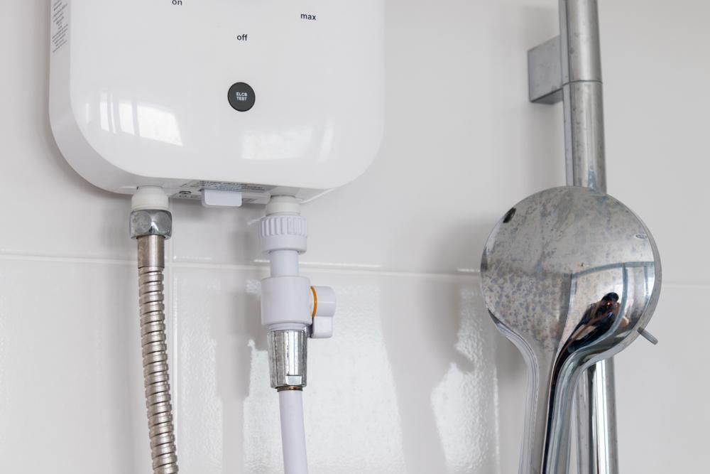 White Instant Water Heater Mounted on a White Tiled Wall — ABV Plumbing In Avoca Beach, NSW