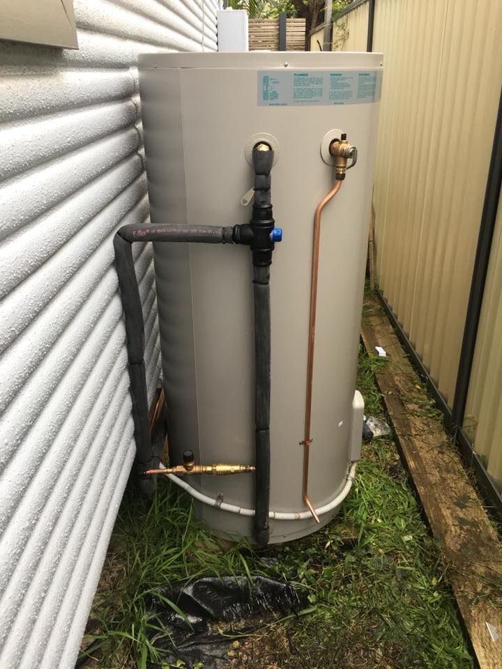 Hot Water Tank Between a White Wall — ABV Plumbing In Woy Woy, NSW