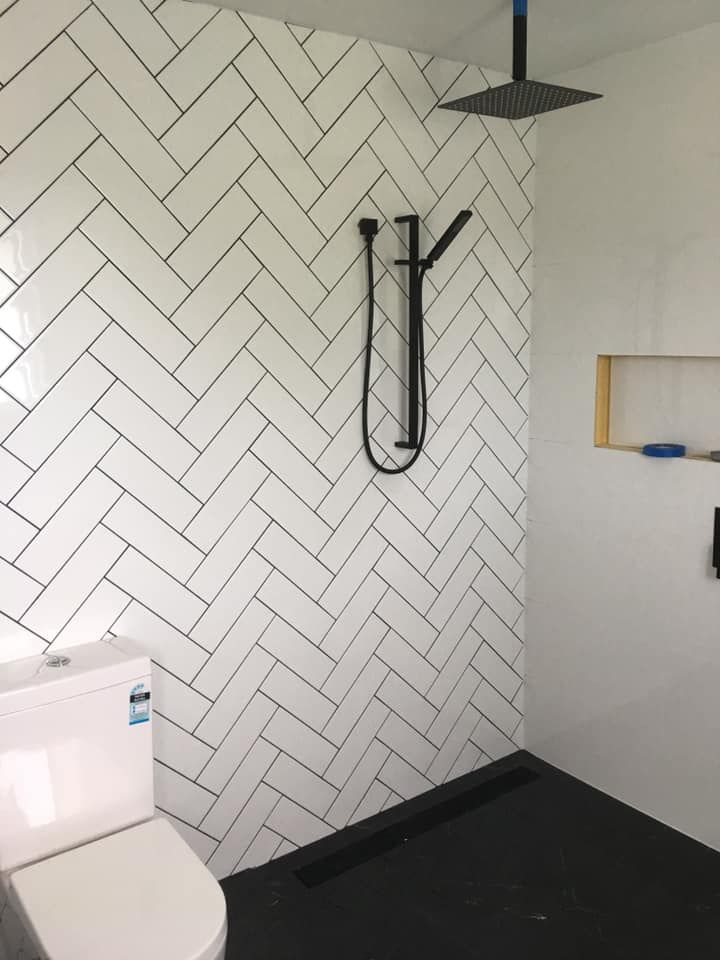 White Herringbone Tiled Shower, Black Fixtures and Black Floor With a Toilet — ABV Plumbing In Woy Woy, NSW