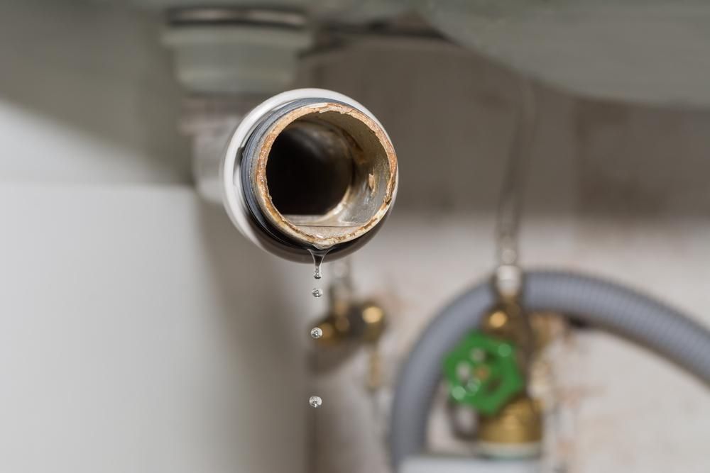 Leaking Pipe With Water Droplets Falling, Set Against a White Wall — ABV Plumbing In Tumbi Umbi, NSW
