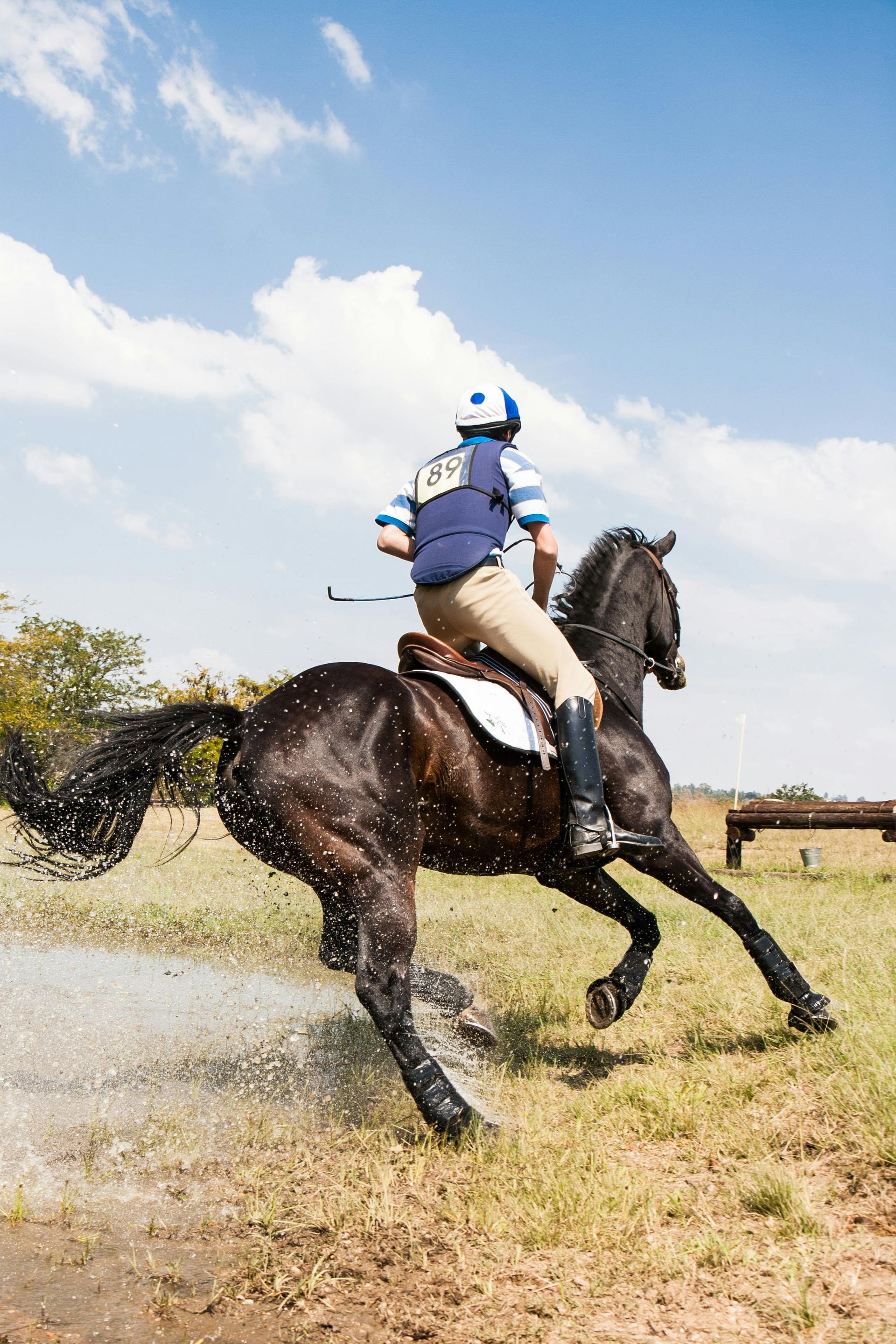 A person is riding a horse through a muddy field.