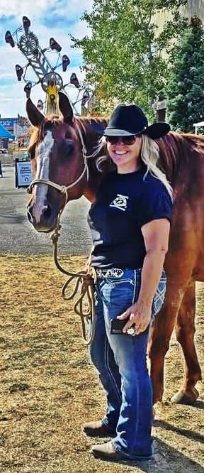 A volunteer with her brown horse.