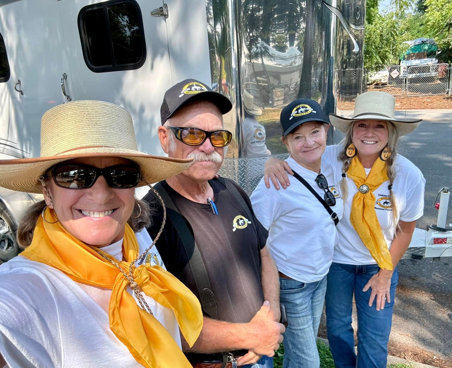 Volunteers posing for a picture in front of a trailer.