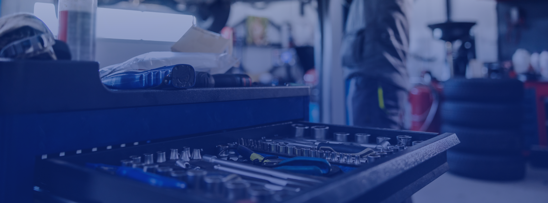 Blue-lit sound mixing console in a blurred studio setup with headphones and equipment in the background | Speedway Auto Care