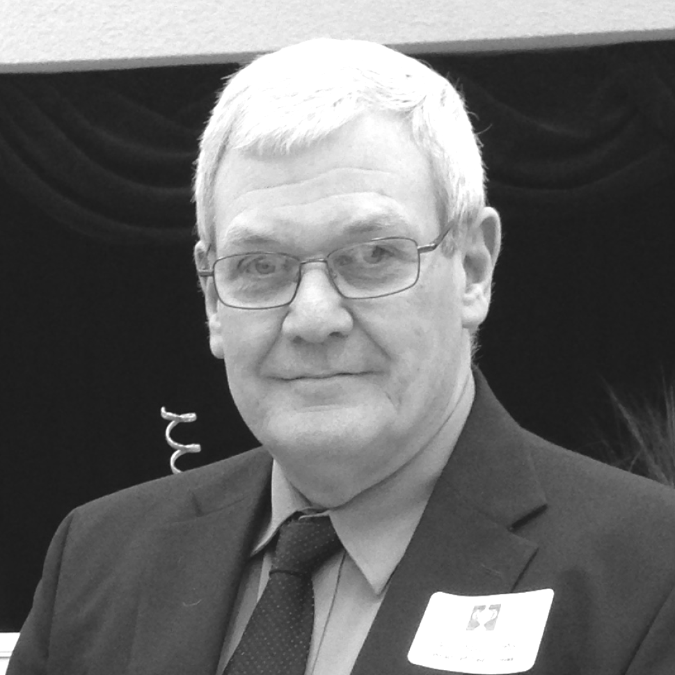 A man in a suit and tie has a name tag that says c7