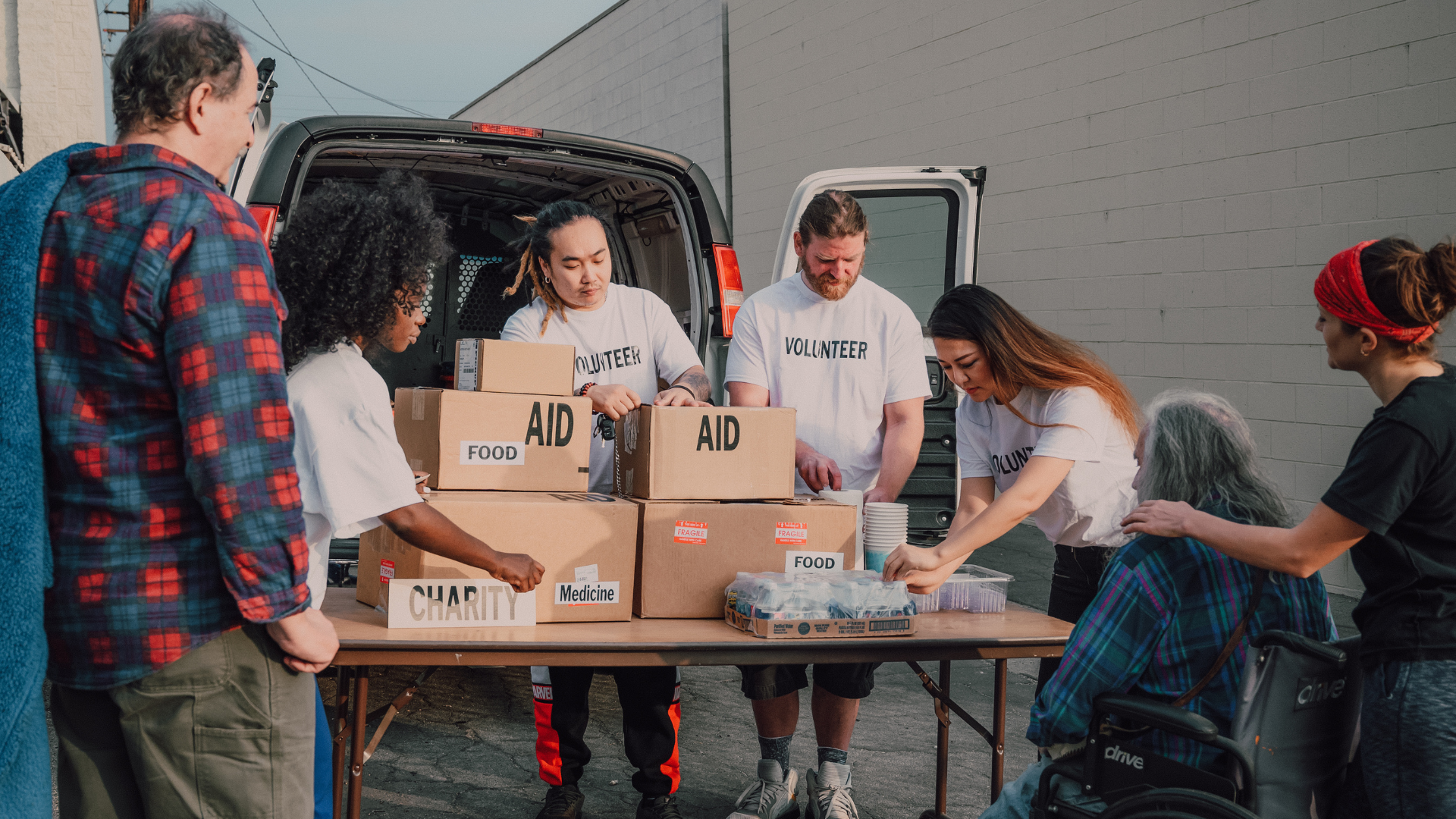 People distributing aid supplies from boxes labeled 