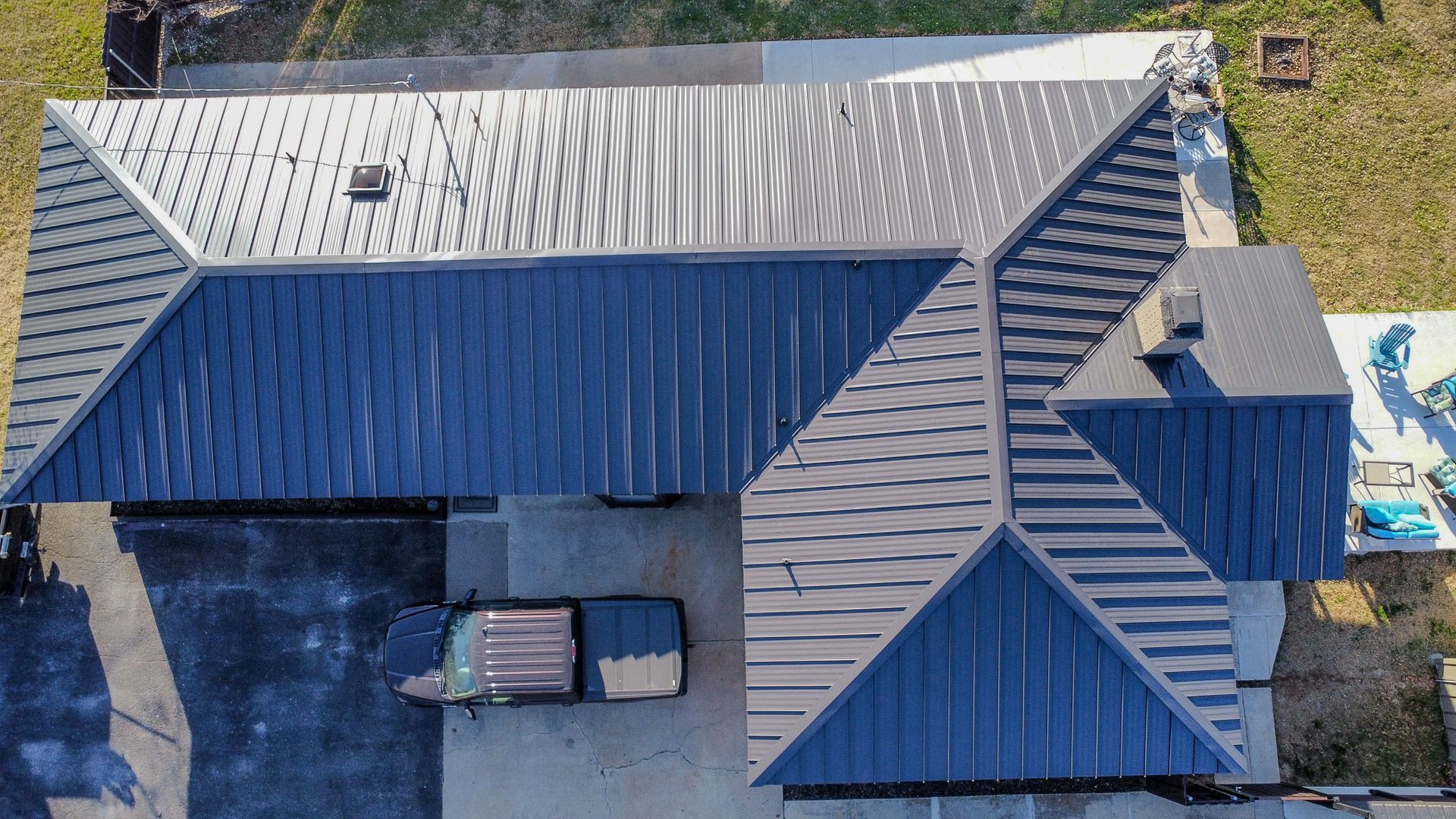 An aerial view of a brick apartment building with a roof that is covered in shingles.