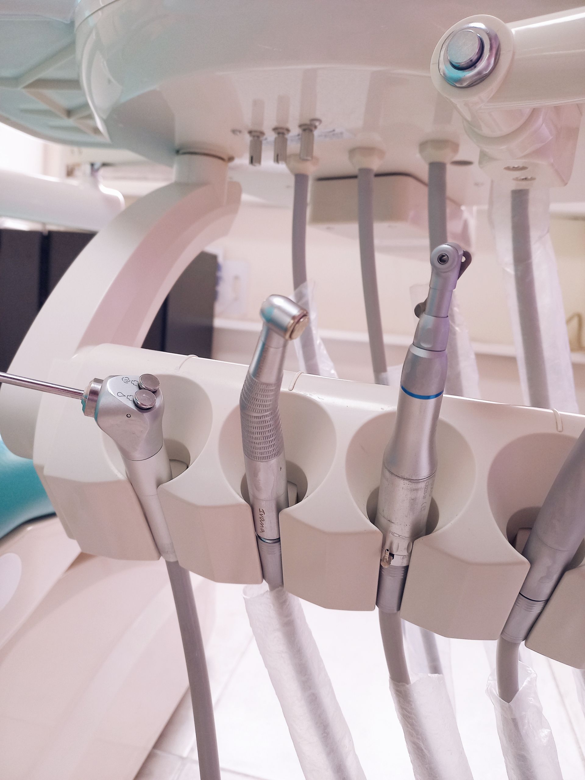 Un montón de instrumentos dentales colgando de una silla dental.