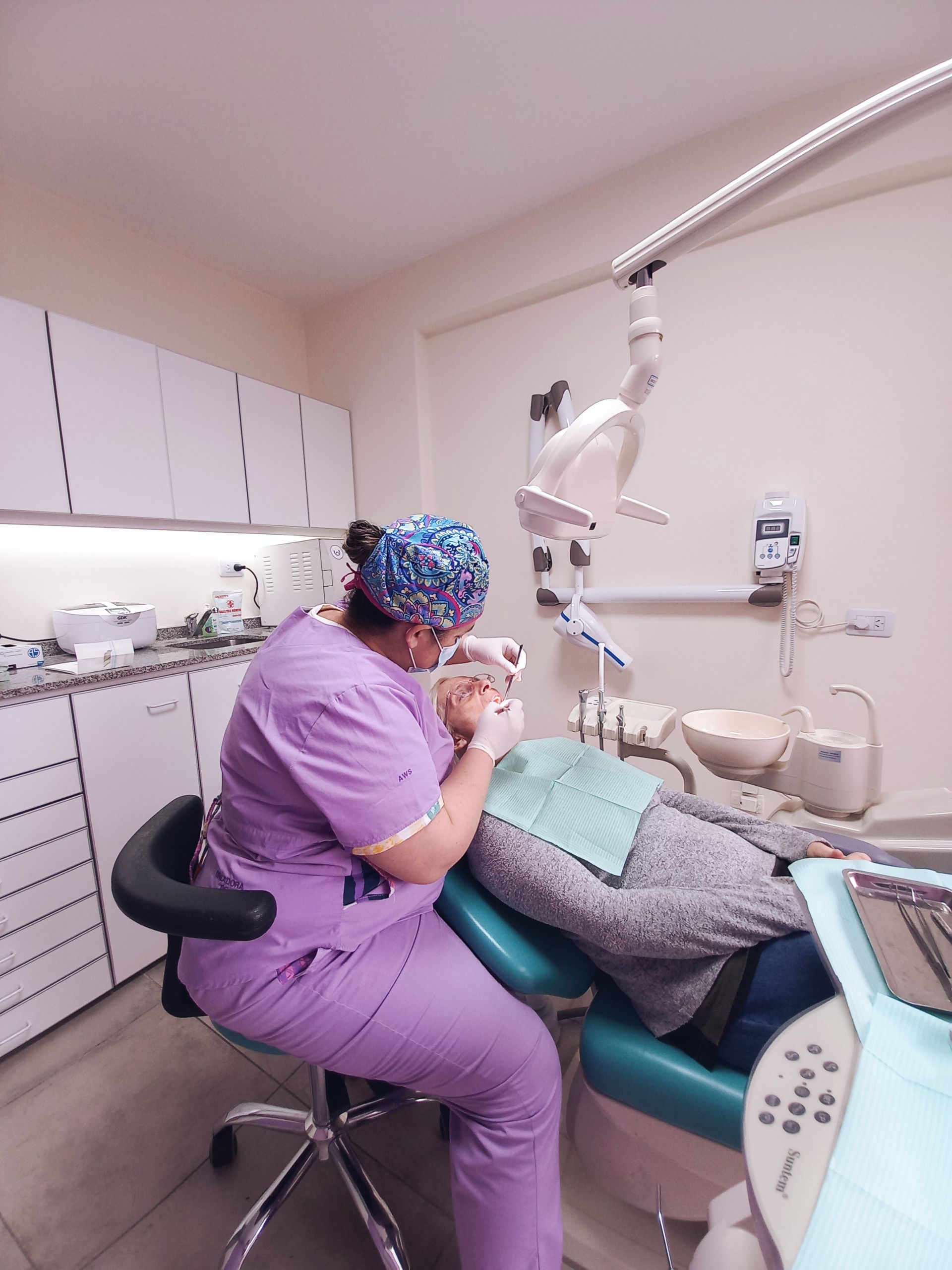 Una dentista examina los dientes de un paciente en un consultorio dental.