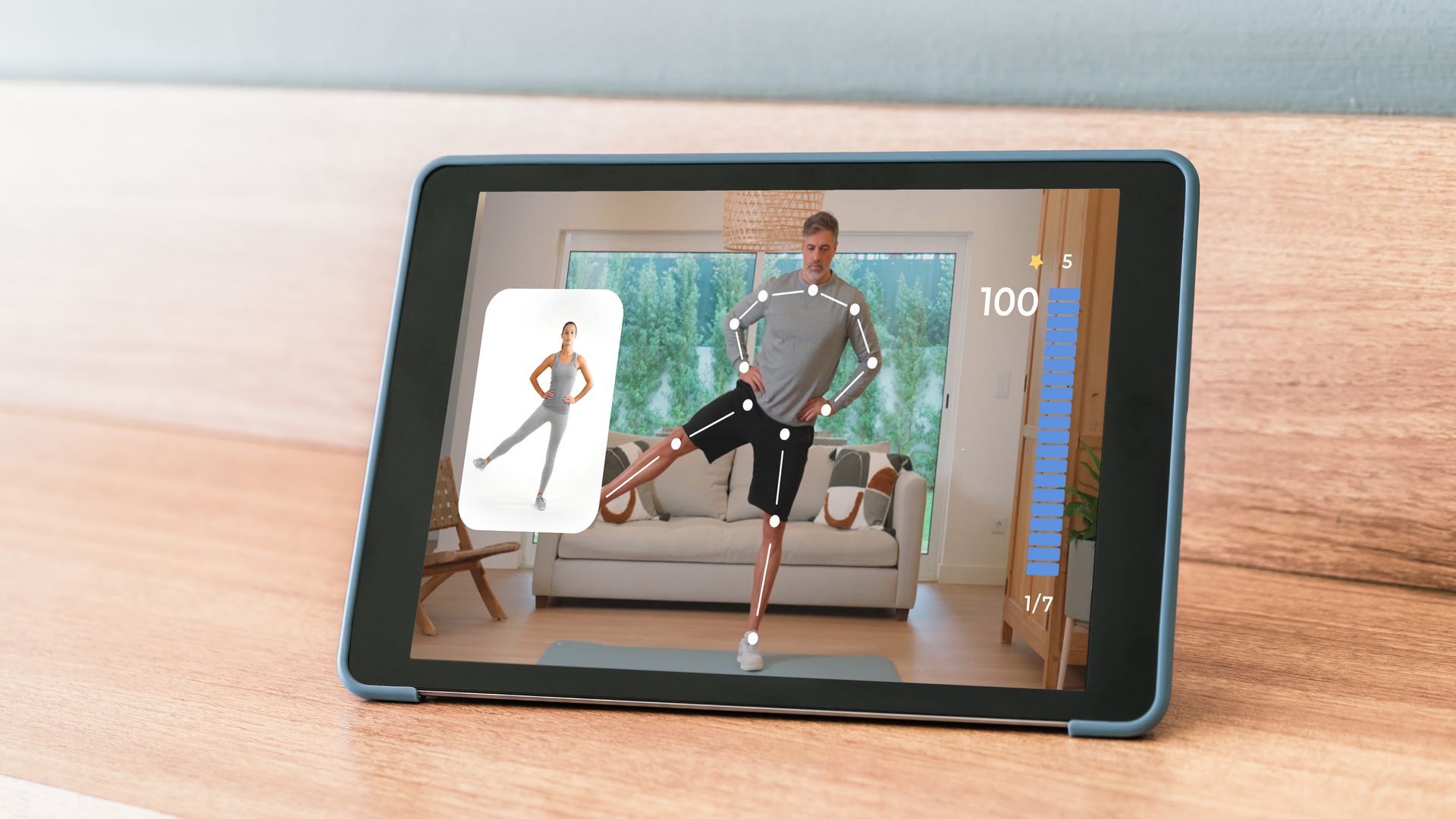 Tablet showing a man exercising, guided by a virtual trainer, in a home setting.