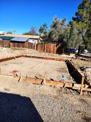 Wooden forms outlining a foundation, ready for concrete pour, outdoors.
