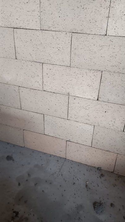 Beige brick wall and concrete floor.