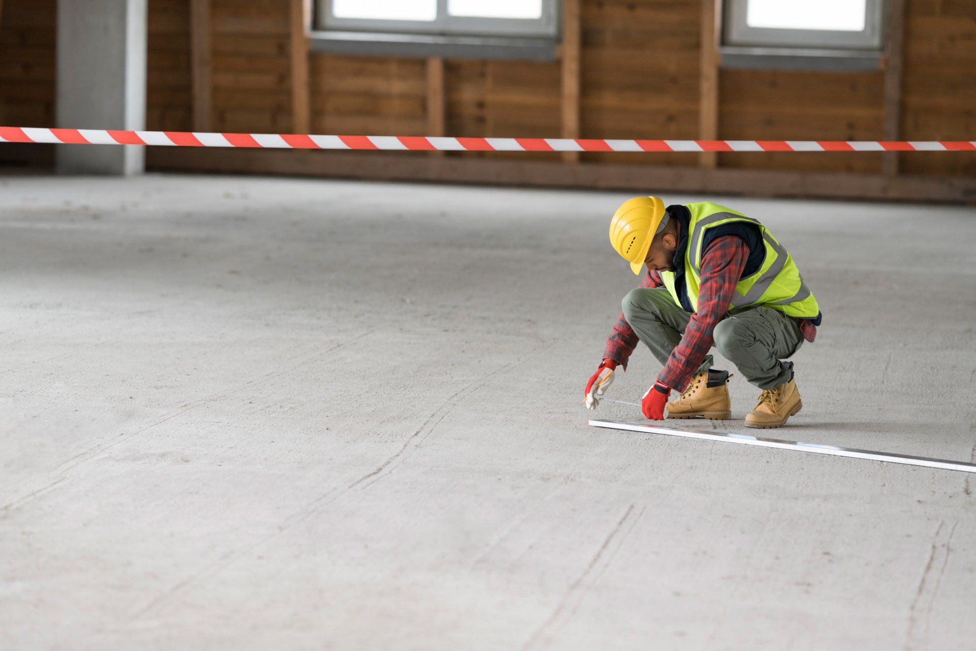 Worker Measuring Concrete Floor — Honolulu, HI — Central Pacific Specialty Contractors