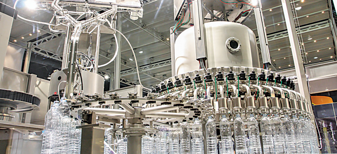 a machine is filling plastic bottles in a factory