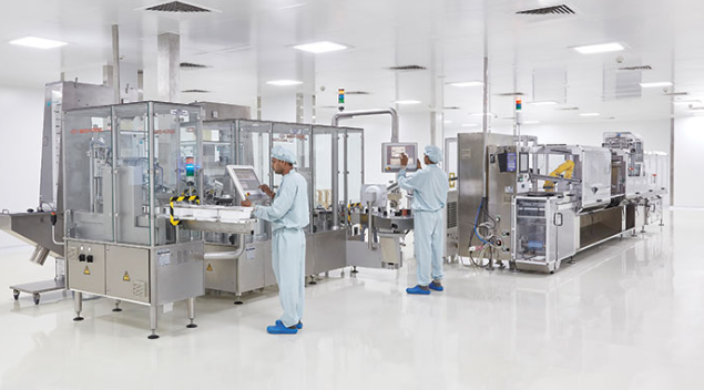 two men are working on a machine in a clean room .