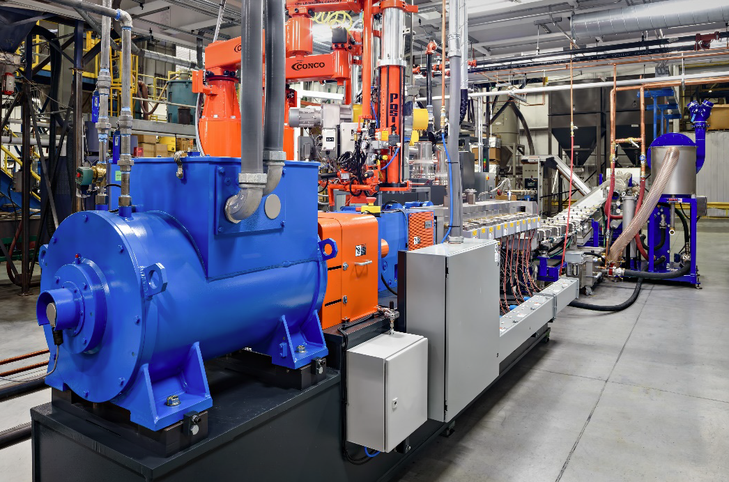 a large blue and orange machine is sitting in a factory .