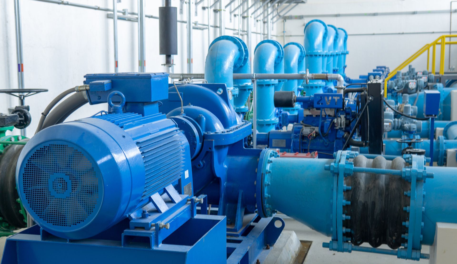 a room filled with lots of blue machinery and pipes .