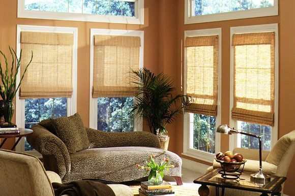Living room with bamboo blinds, tan walls, and a cheetah-print chaise lounge.