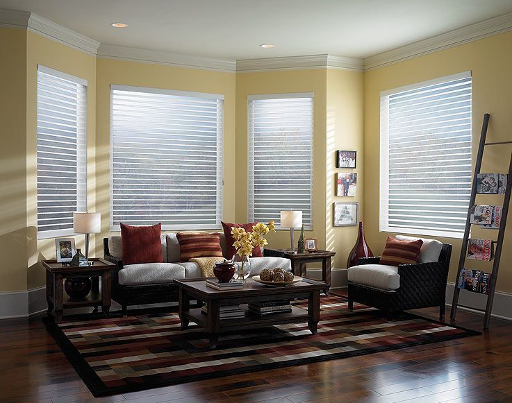 Living room with yellow walls, sectional sofa, area rug, and blinds.